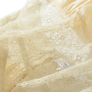 Détail en dentelle d'une robe dos nu beige à col en V avec doublure en satin
