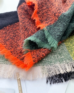 Close-up of colorful checkered scarf fabric with soft wool texture and fringe detail