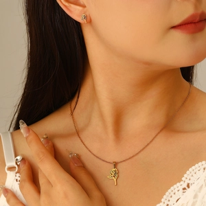 Elegant gold stainless steel jewelry set featuring hollow rose pendant and matching earrings