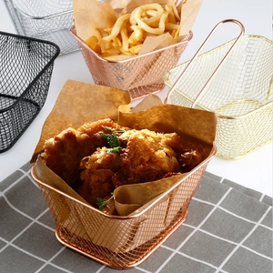 Paniers à friture en inox doré et or rose avec frites et snacks sur la table