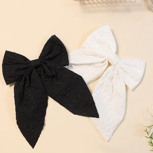 Close-up of set of 2 large solid color ribbon hair bows in black and white textured fabric