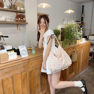 Close-up of a floral canvas tote bag featuring pink blossom prints and wide strap
