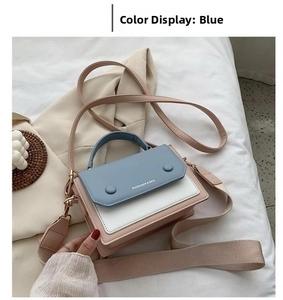 Detail of color-block flap bag in blue, white, and pink with adjustable woven wide strap
