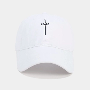 Detail of black PEACE embroidery and texture on a white cotton baseball cap