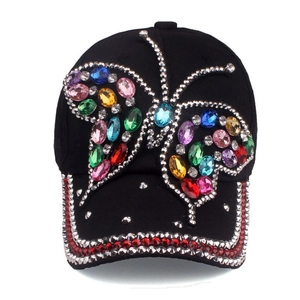 Close-up of black denim baseball cap featuring vibrant multi-color rhinestone butterfly detail