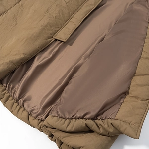 Detailed close-up of brown quilted coat lining with elastic hem for warmth