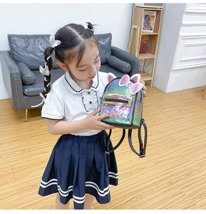 Detail of colorful sequined mini backpack with cat ears and bow on a young child