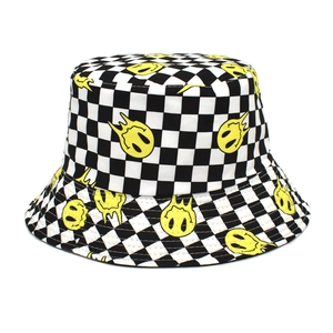 Détail d'un bob à damier avec motif de visage souriant jaune sur fond blanc