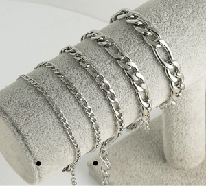 Polished stainless steel Figaro chain bracelets in multiple widths on display