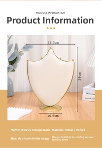 Macro detail of a 29cm shield-shaped cream velvet jewelry stand with gold metal frame