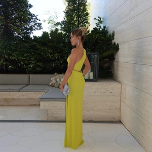 Detail of elegant yellow one-shoulder bodycon maxi dress for women in soft natural light
