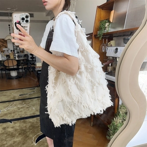 Mirror selfie showing the large white fringe canvas tote bag for daily wear and style