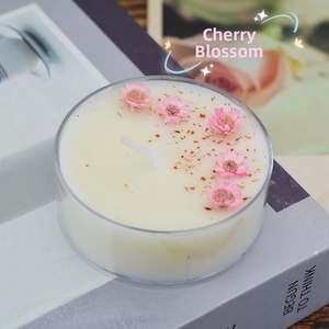 Macro shot of handmade cherry blossom scented tealight with pink dried flowers on top