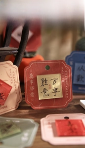 Close-up of traditional Chinese style acrylic magnets with calligraphy on wooden surface