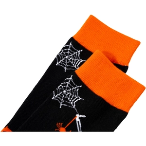 Detail shot of knitted Halloween socks with orange spider web patterns on black fabric