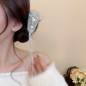 Macro detail of rhinestone tassels and grey flocked base on high-end fashion hair clip