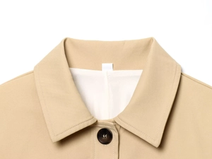 Detail of khaki blazer lapel featuring a single resin button and fine fabric texture