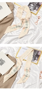 Detail showing beige silk scarf with blue dots and Fashion script on soft background