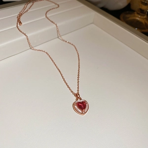 Elegante collana a cuore in oro rosa con zircone rosso e madreperla su base color crema