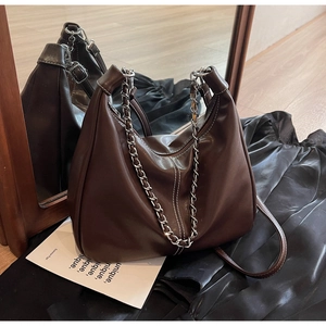 Detailed close-up of dark brown PU leather hobo bag with silver chain and white stitching