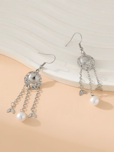Detail view of silver tassel earrings with sun charms, leaf accents, and pearls