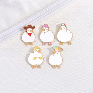 Set of 5 cute cartoon duck enamel pins with various outfits on a white canvas bag