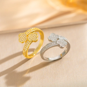 Detailed close-up of gold and silver four-leaf clover rings with pavé zircon settings