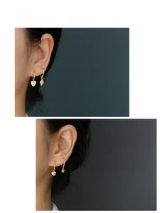 Detail shot of gold heart and star earrings with pavé stones on a female model