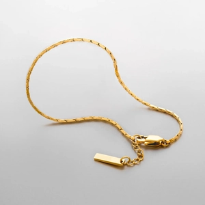 Vue détaillée du bracelet gourmette en acier titane doré avec fermoir et étiquette