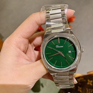 Close-up of green dial watch with steel band and calendar display held by hand