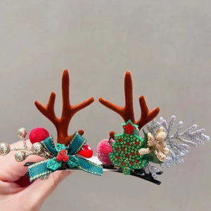Detail of Christmas reindeer antler hair clip with red berries and green ribbon bow