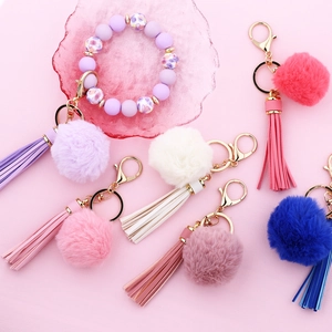 Mix of colorful 5cm faux fur pompom keychains with leather tassels and beaded bracelet