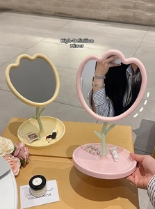 Detail of tulip shaped makeup mirror with flower petal frame and storage base tray