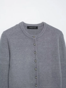 Dettaglio cardigan in maglia grigia con bottoni metallici e morbida trama in lana
