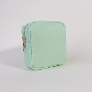 Detailed shot of light green nylon storage pouch featuring a durable gold metal zipper