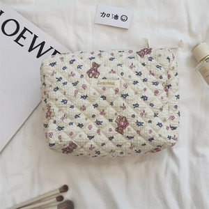 Détail de la trousse à maquillage matelassée avec motifs d'ours et fermeture éclair