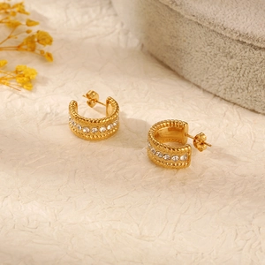Detailed shot of gold-plated stainless steel C-hoop earrings with central diamond inlay