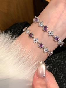 Close-up of hexagonal clasp bracelets featuring purple zircon flowers and silver plating