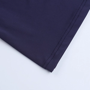 Vue macro du tissu en maille bleu marine montrant les doubles coutures et la texture fine