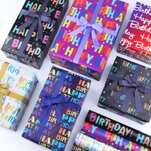 Macro view of birthday kraft wrapping paper rolls with colorful Happy Birthday patterns