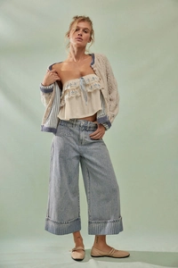 Detail einer hellblauen gestreiften Jeans kombiniert mit beiger Strickjacke und Spitzentop