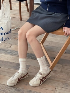 Close-up of soft ribbed crew socks in white and pink stripes worn with casual sneakers