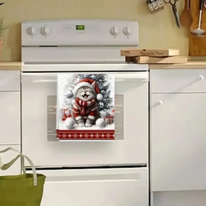 Christmas kitchen towel with a cat wearing a Santa hat hanging on a white oven handle
