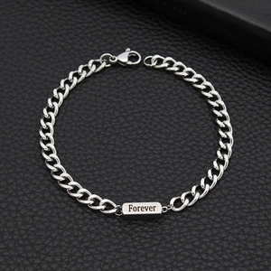 Detailed macro view of silver stainless steel Cuban chain bracelet with Forever engraving