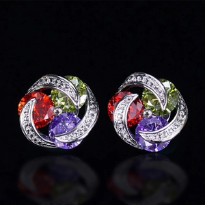 Macro detail of silver floral stud earrings featuring colorful zircons and clear crystals
