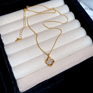 Detailed macro view of 18k gold plated hollow square pendant with sparkling cubic zirconia