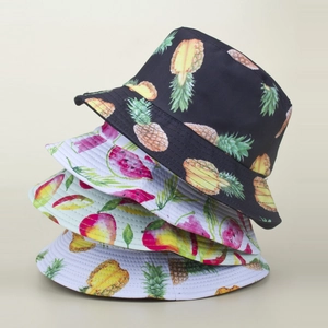 Detail showing stacked bucket hats with pineapple and watermelon prints in high quality