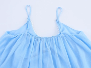 Close-up of light blue chiffon dress with delicate pleats and white lace trim detail