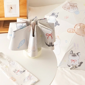 Cream cat print automatic sun and rain umbrella with matching pouch in home setting