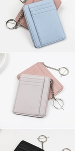 Tre porta carte in pelle PU testurizzata multicolore con portachiavi su sfondo bianco